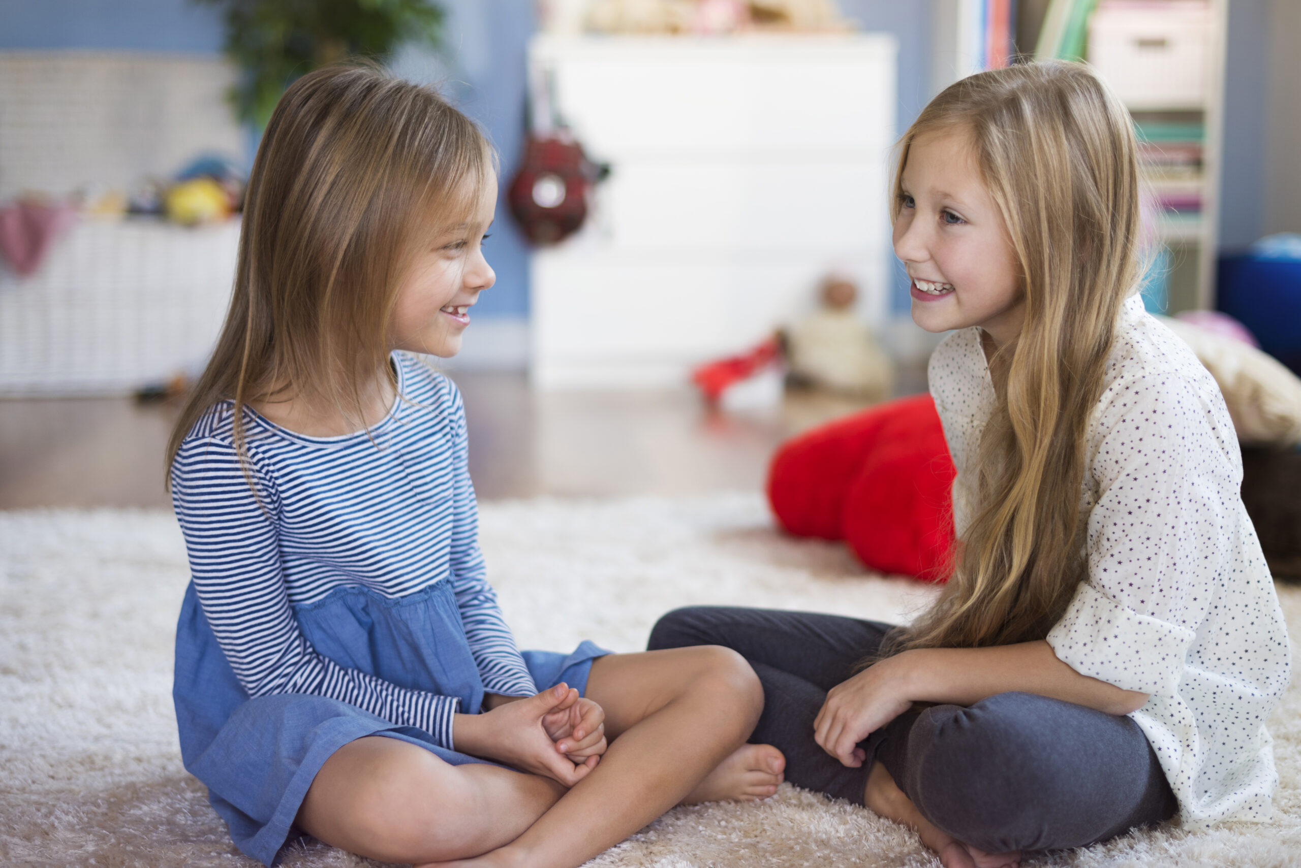Girls talking to each other in the living room Girls talking to each other in the living room