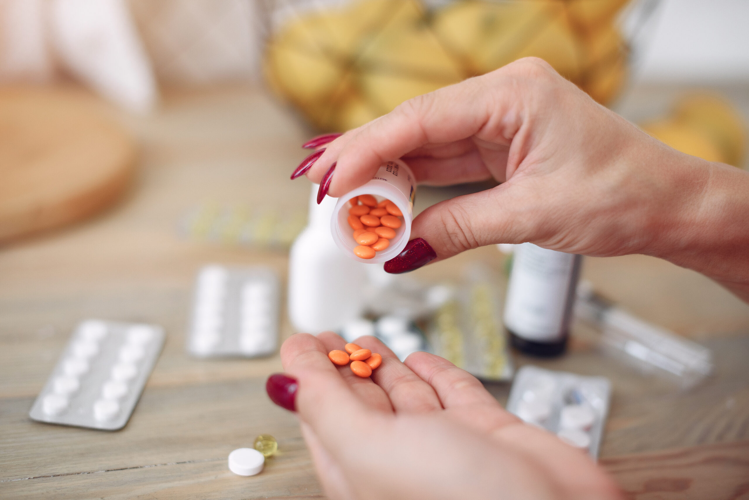 Woman sitting at home with a cold and taking pills Woman sitting at home with a cold and taking pills