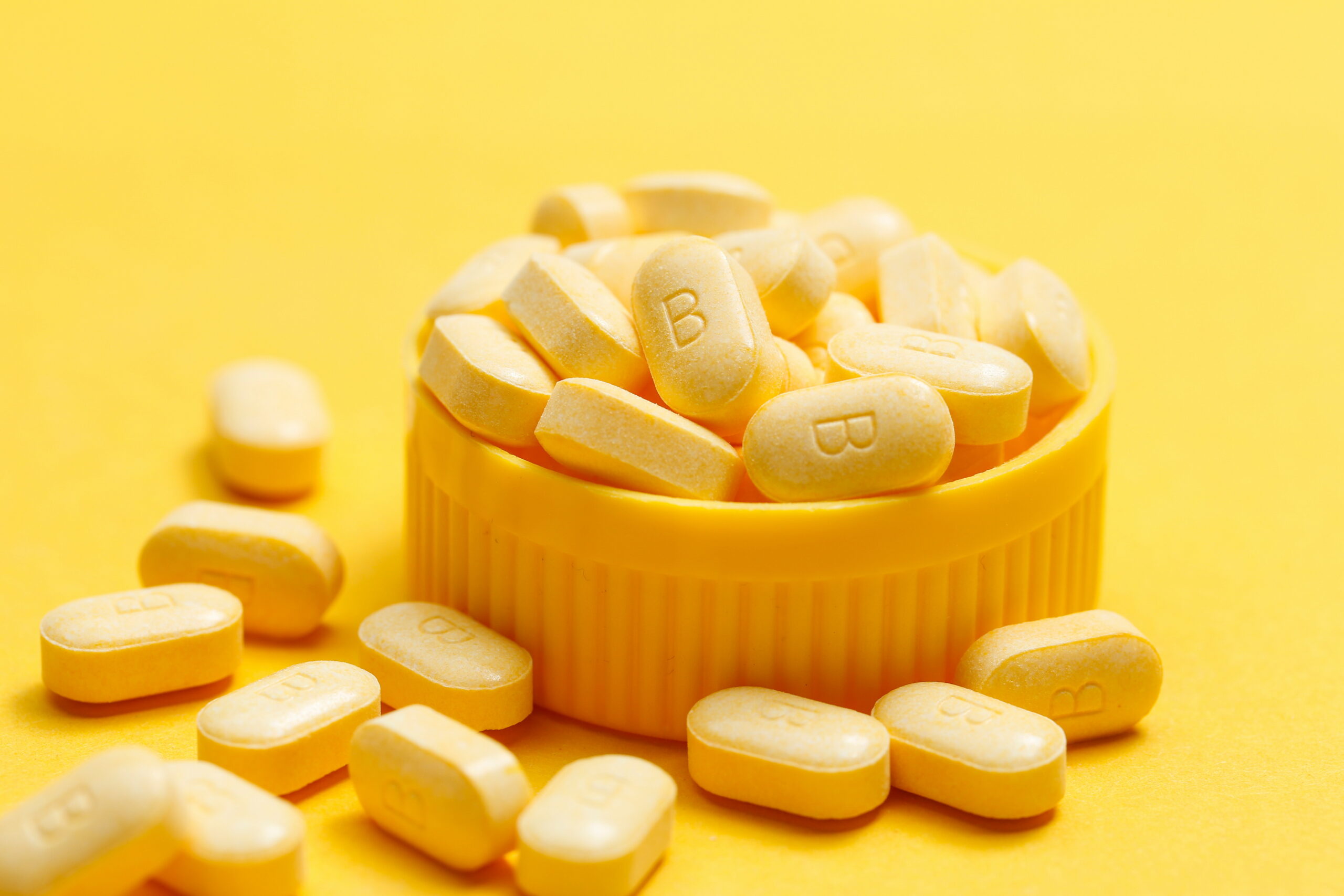 vitamin B tablets on yellow background vitamin B tablets on yellow background