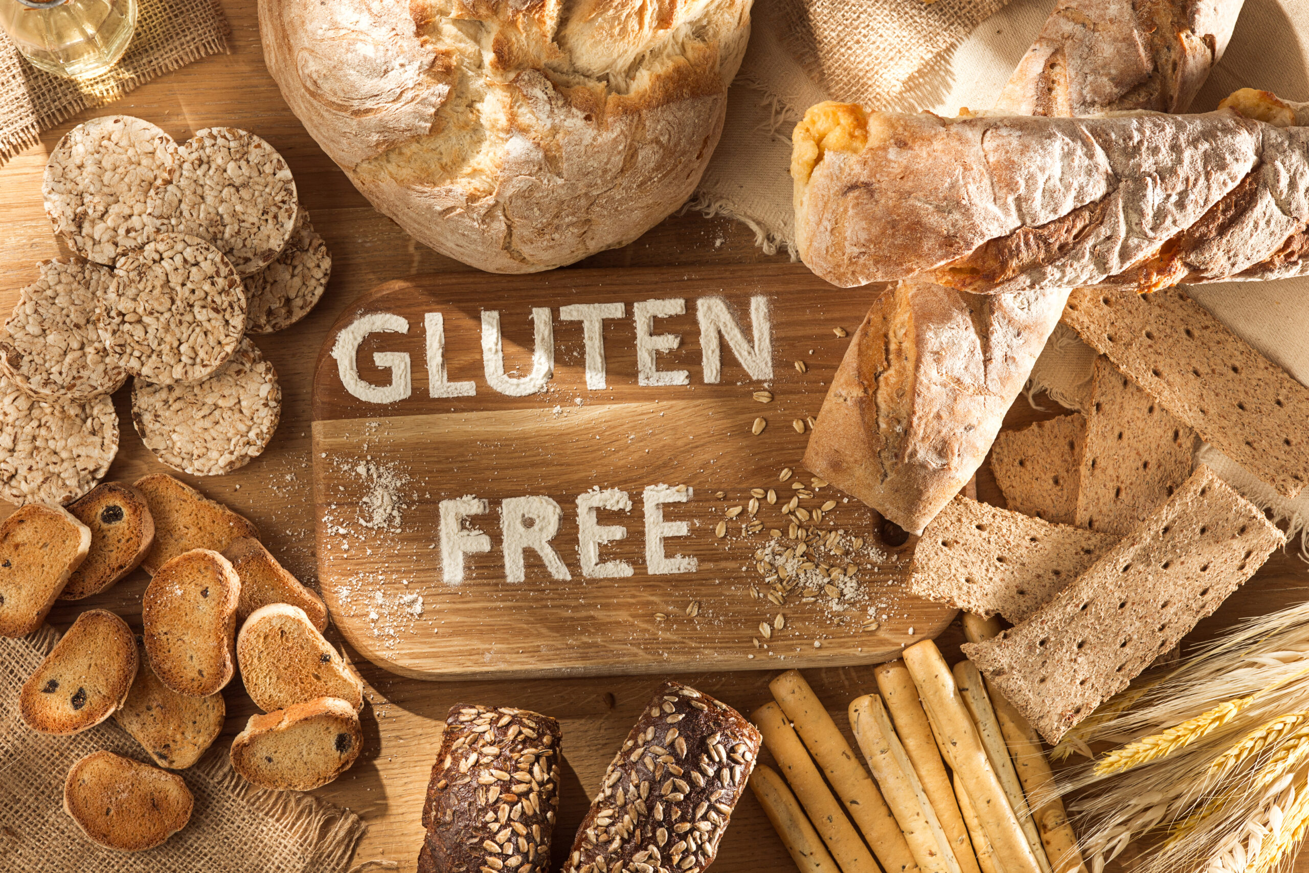 Gluten free food. Various pasta, bread and snacks on wooden background from top view