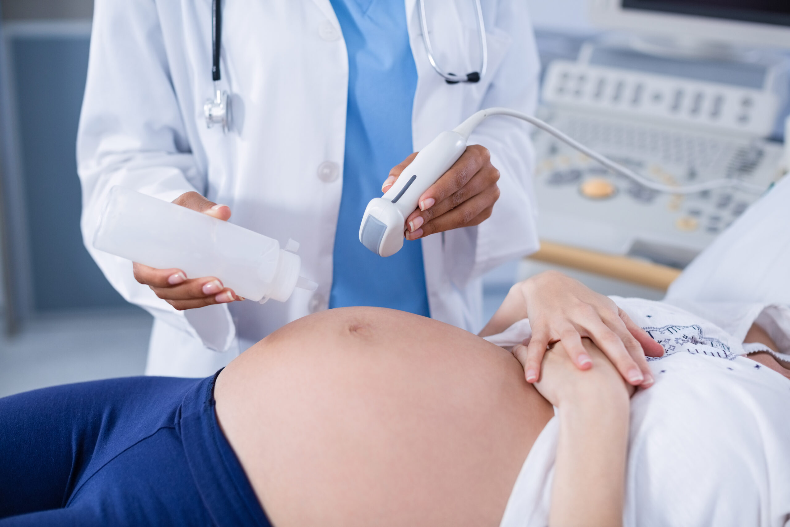 Pregnant woman receiving a ultrasound scan on the stomach in hospital Pregnant woman receiving a ultrasound scan on the stomach in hospital