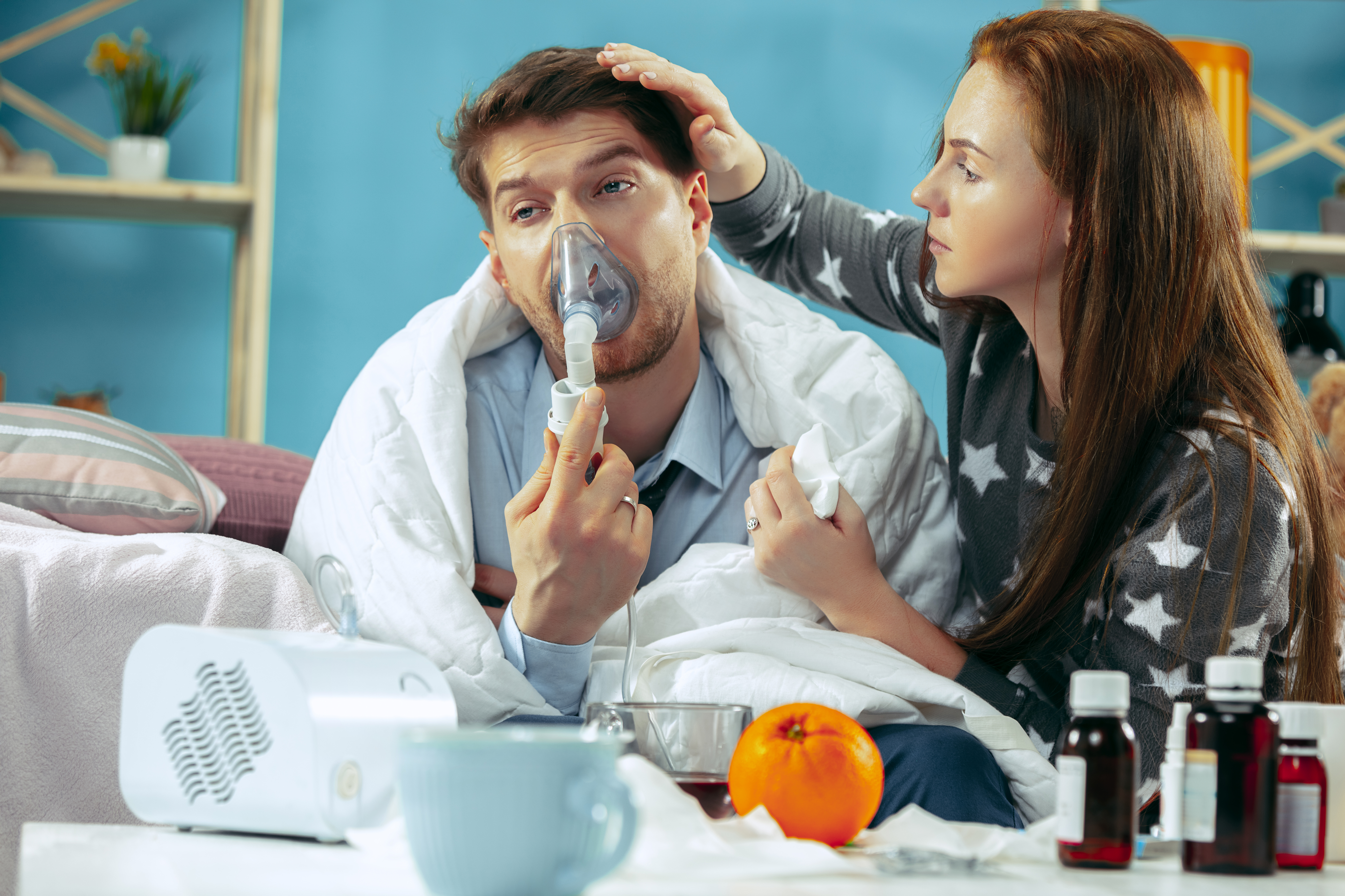 Sick man with fever lying in bed having temperature girl take care for him Sick man with fever lying in bed having temperature girl take care for him