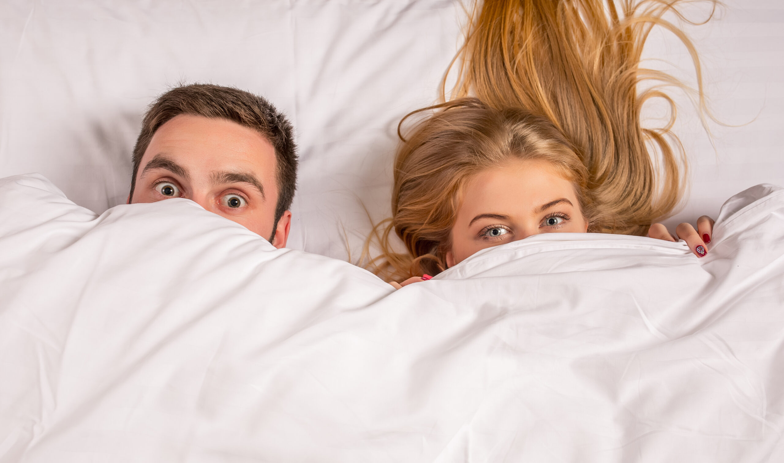 Young lovely couple lying and have fun in a bed Young lovely couple lying and have fun in a bed