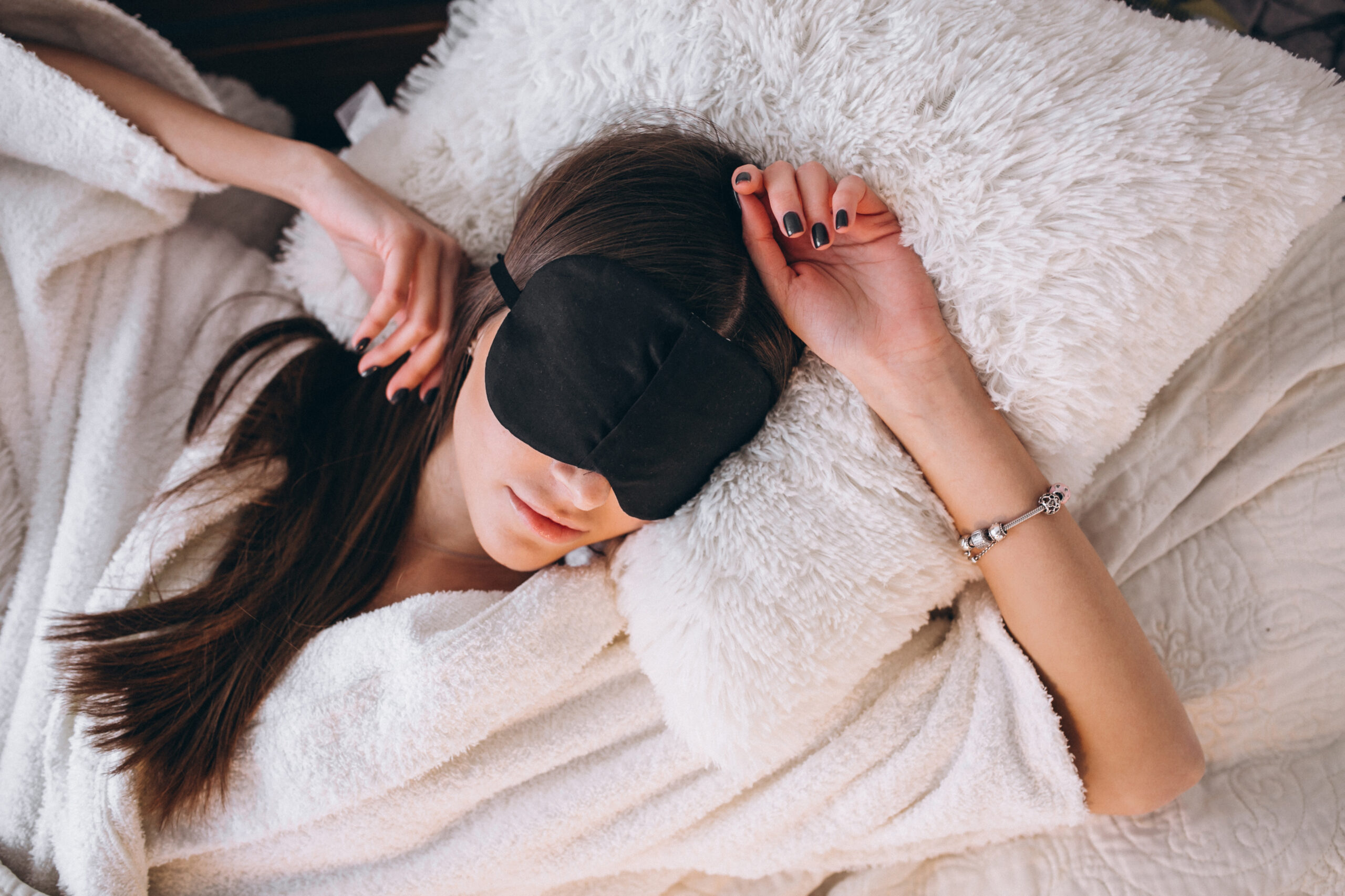 Woman in bed wearing sleeping mask Woman in bed wearing sleeping mask