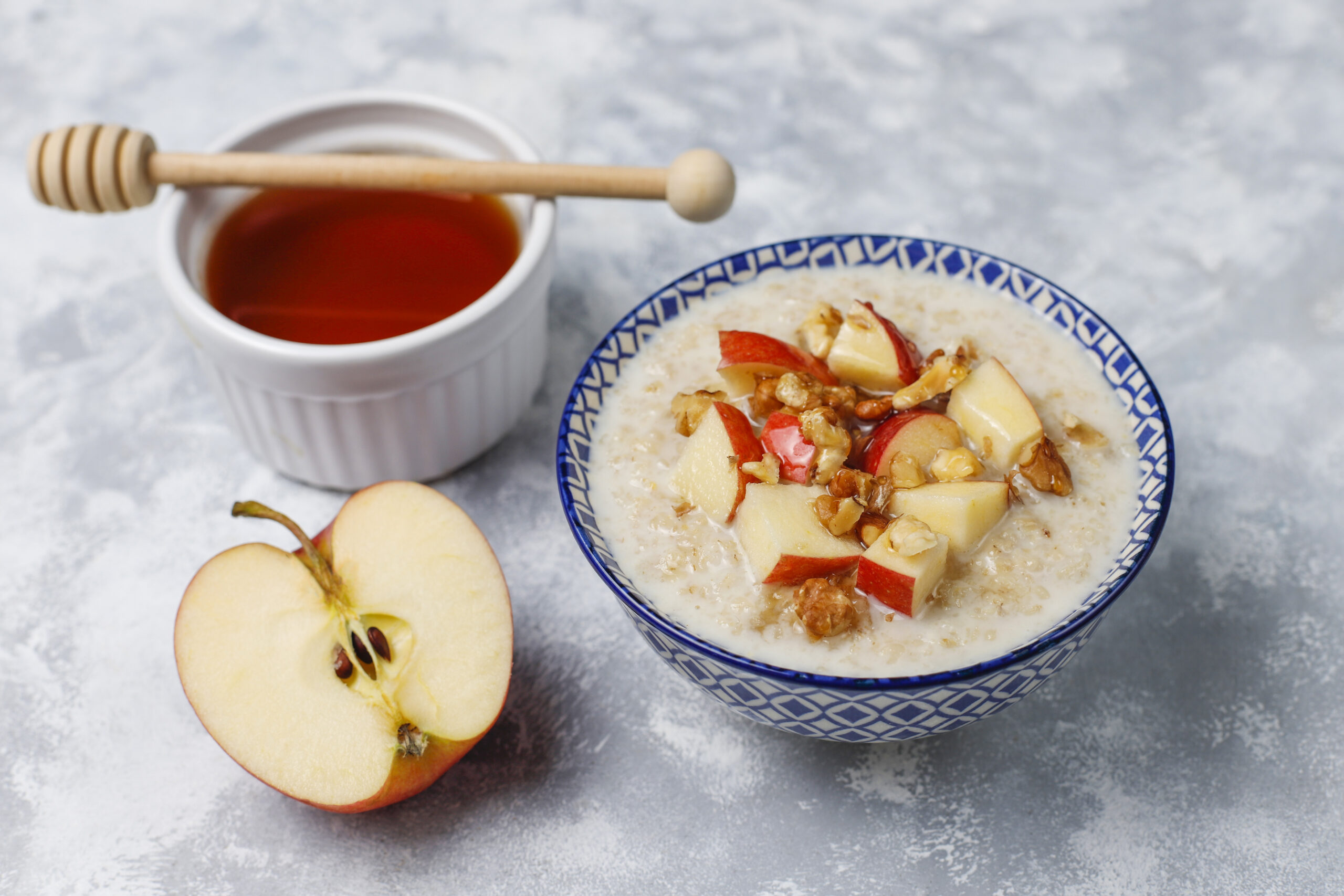 Oatmeal porridge in a bowl with honey and red apple slices,top v Oatmeal porridge in a bowl with honey and red apple slices,top v