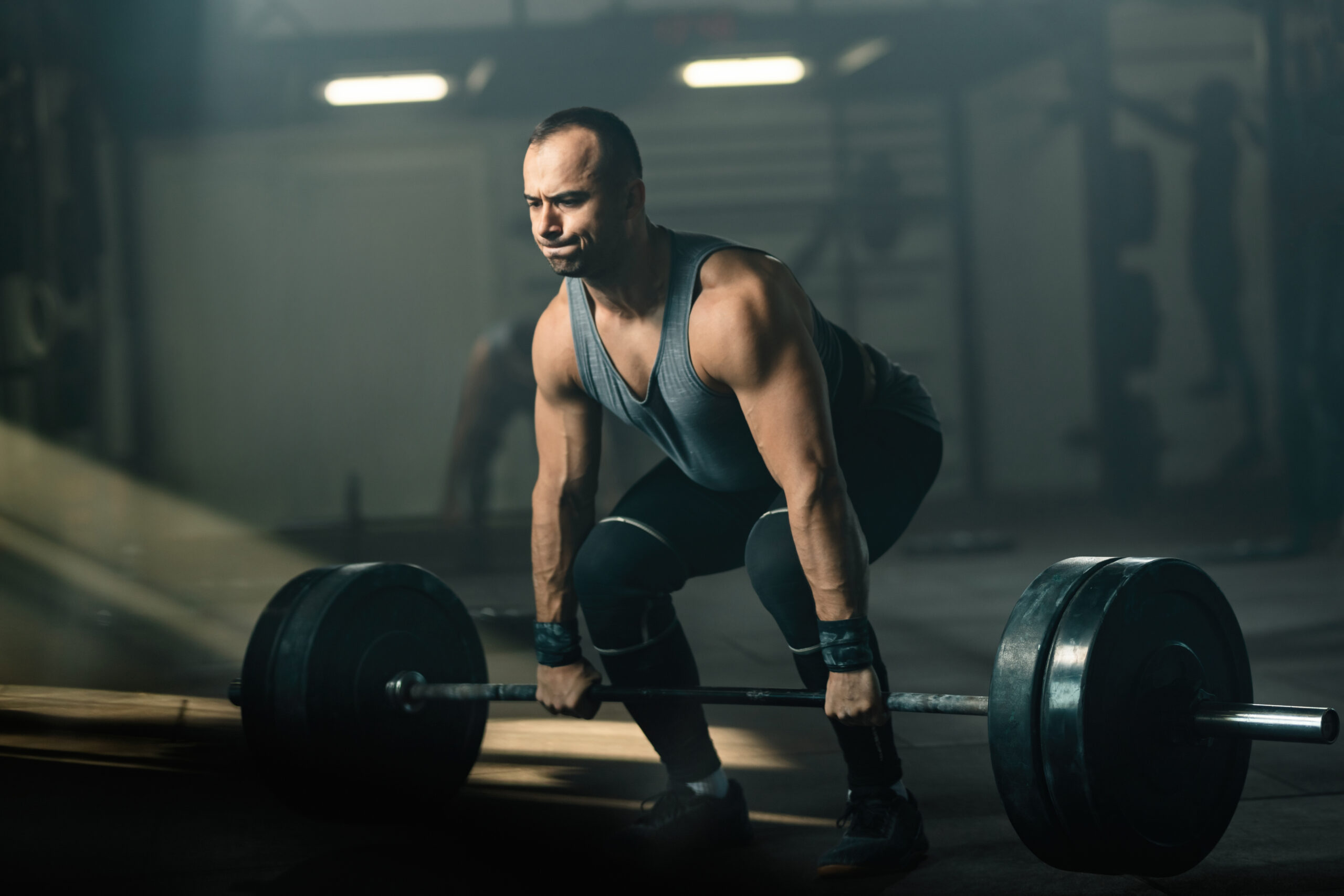 Determined bodybuilder exercising deadlift with barbell in healt Determined bodybuilder exercising deadlift with barbell in healt