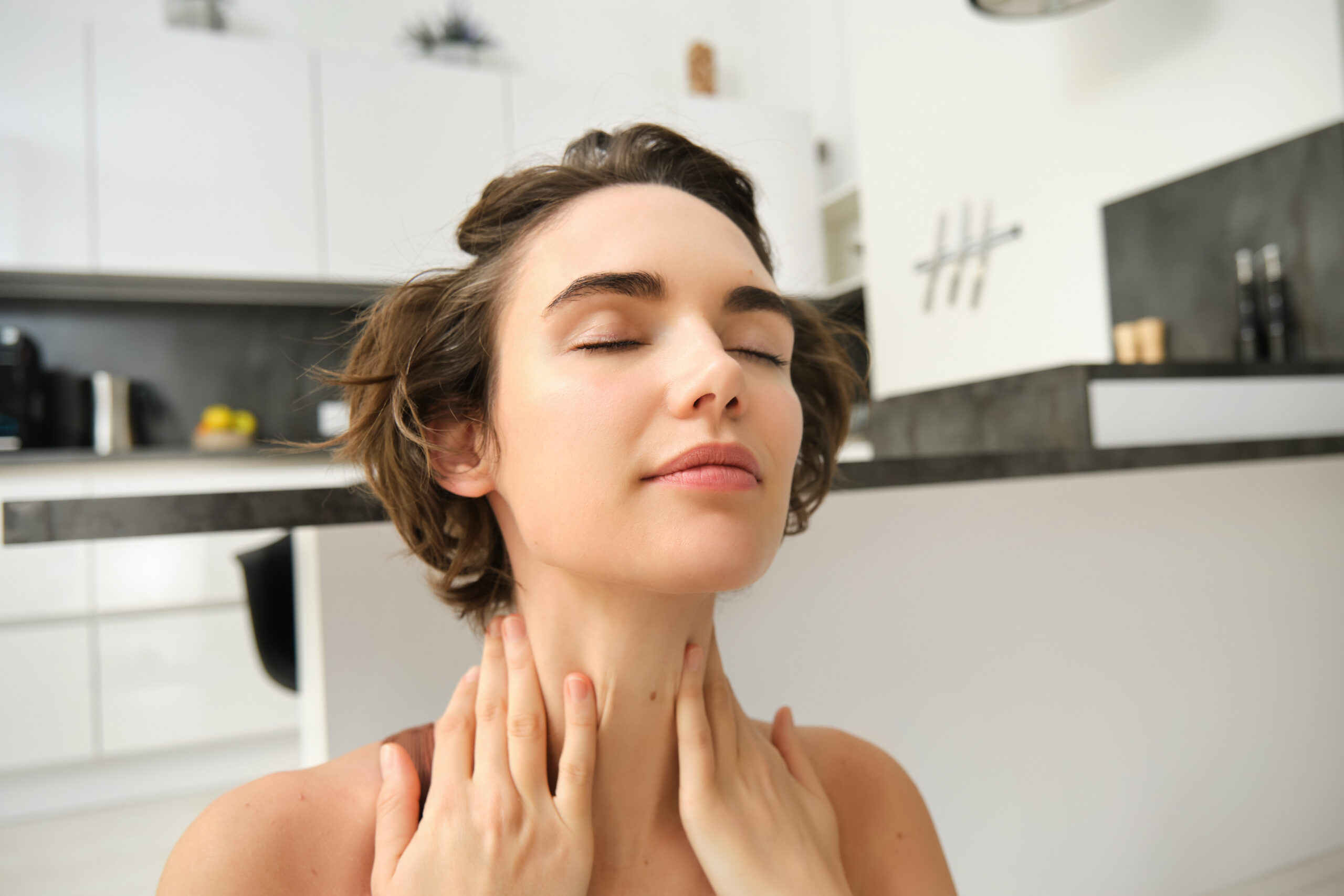Close up portrait of sportswoman, fitness woman massaging her neck, warm-up her body after workout, doing yoga on rubber mat at home Close up portrait of sportswoman, fitness woman massaging her neck, warm-up her body after workout, doing yoga on rubber mat at home