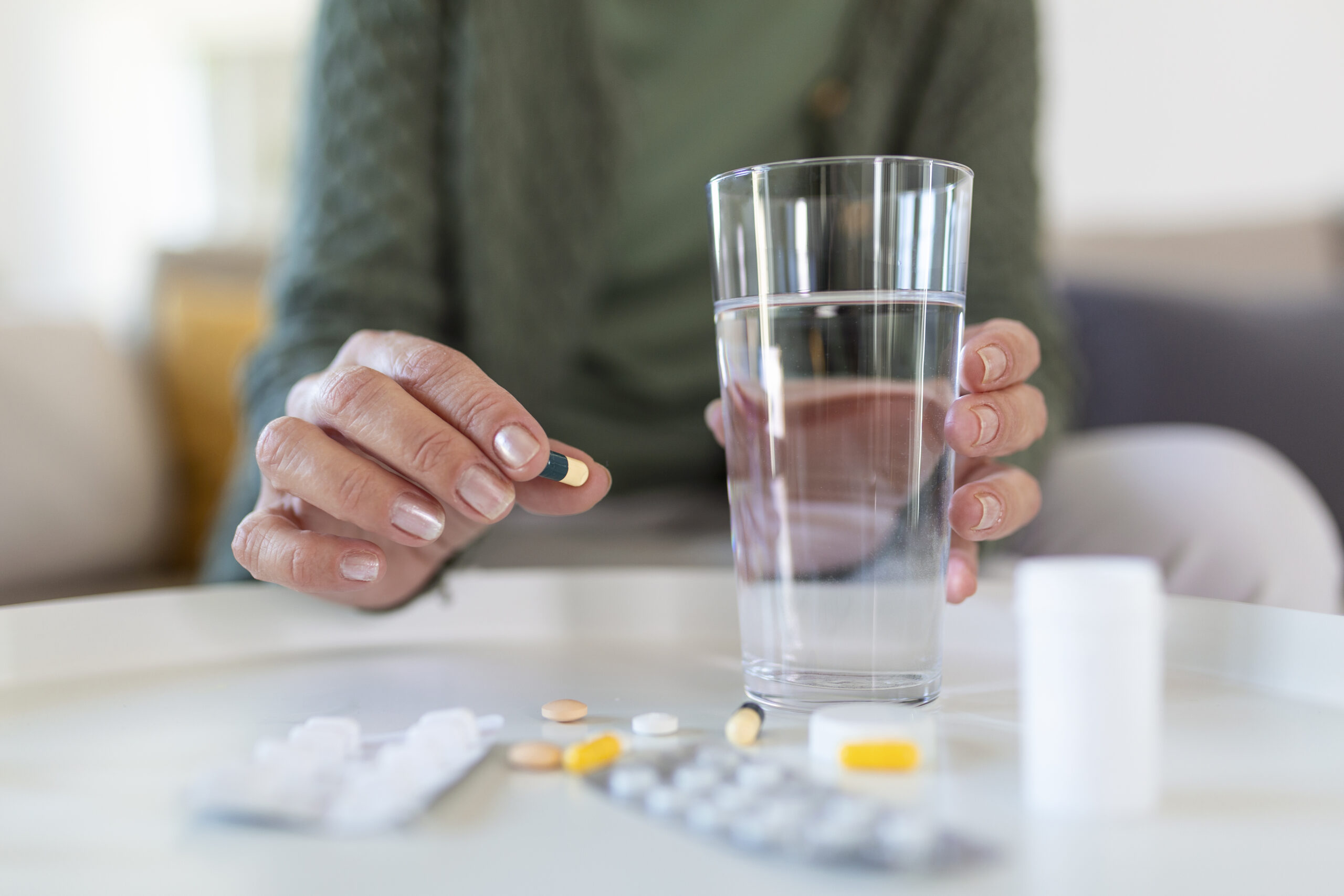 Senior woman takes pill with glass of water in hand. Senior woman takes pill with glass of water in hand.