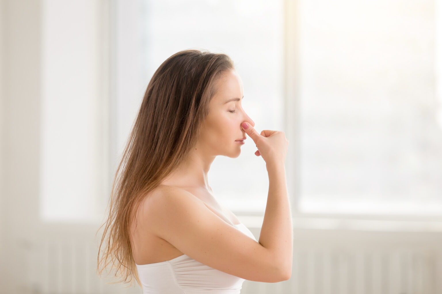 Young attractive woman making Alternate Nostril Breathing, white Young attractive woman making Alternate Nostril Breathing, white