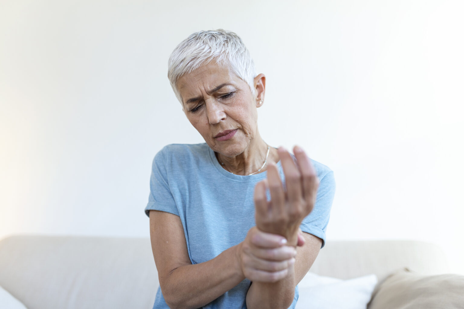 Elderly woman suffering from pain in hand, arthritis old person and senior woman female suffering from pain at home Elderly woman suffering from pain in hand, arthritis old person and senior woman female suffering from pain at home