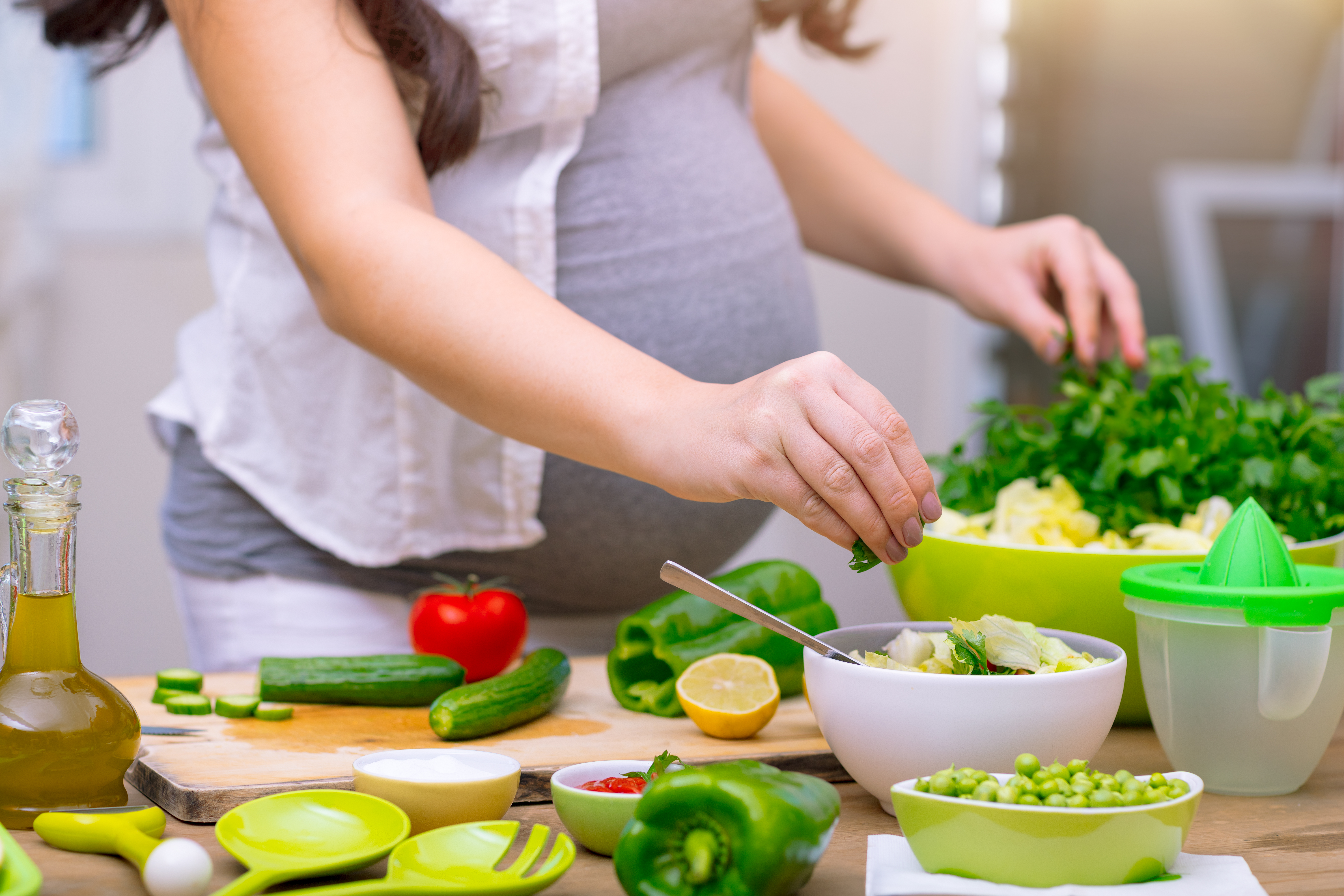 Happy,Pregnant,Woman,Cooking,At,Home,,Doing,Fresh,Green,Salad,
