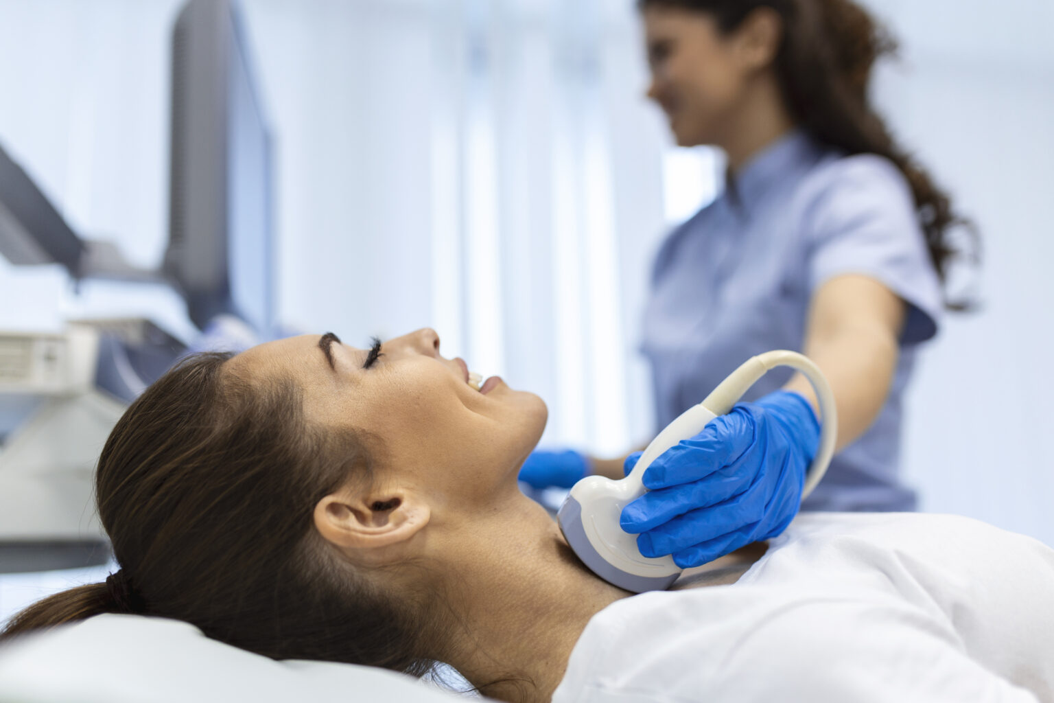 Woman patient receives thyroid diagnostics. Treatment of thyrotoxicosis, and hypothyroidism. Ultrasound diagnostics of the endocrine system and thyroid Woman patient receives thyroid diagnostics. Treatment of thyrotoxicosis, and hypothyroidism. Ultrasound diagnostics of the endocrine system and thyroid