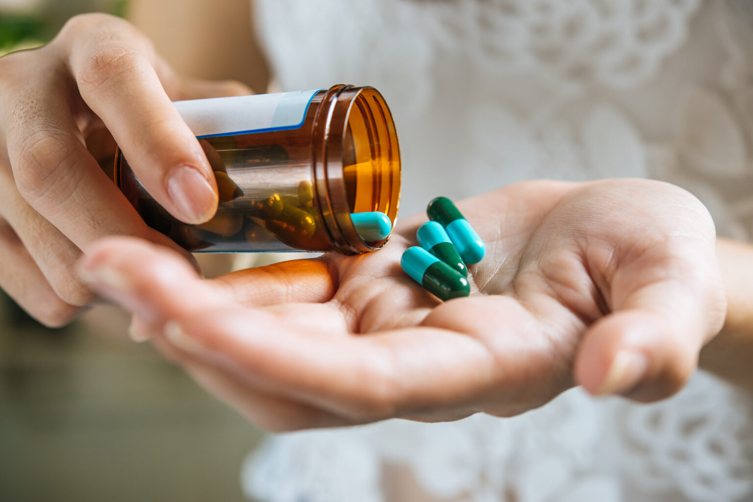 Woman’s hand pours the medicine pills out of the bottle Woman’s hand pours the medicine pills out of the bottle