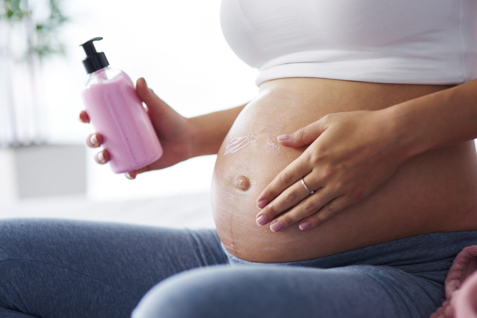 Pregnant women applying cream Pregnant women applying cream