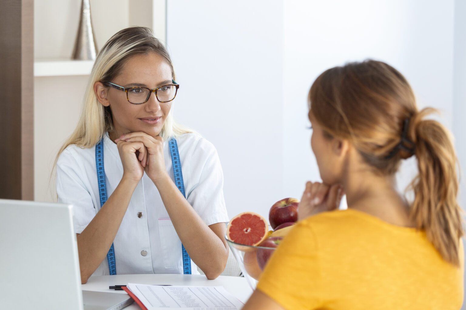 Female nutritionist giving consultation to patient. Making diet plan. Young woman visiting nutritionist in weight loss clinic Female nutritionist giving consultation to patient. Making diet plan. Young woman visiting nutritionist in weight loss clinic