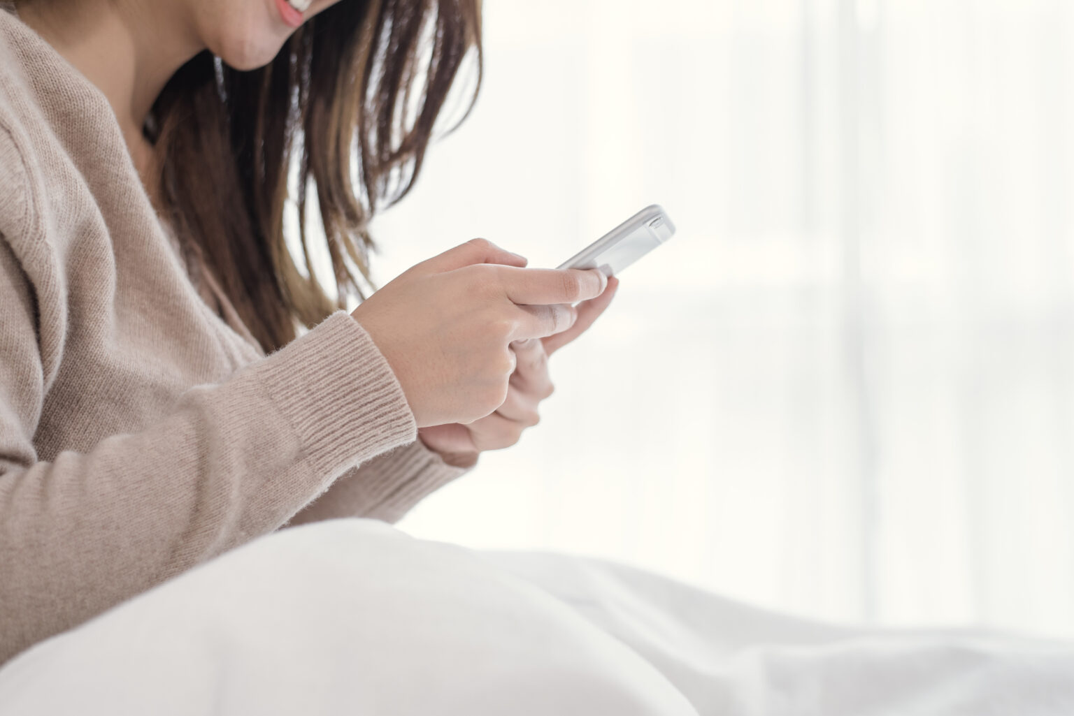 Happy Asian women are using smart phone on the bed in morning. A Happy Asian women are using smart phone on the bed in morning. A