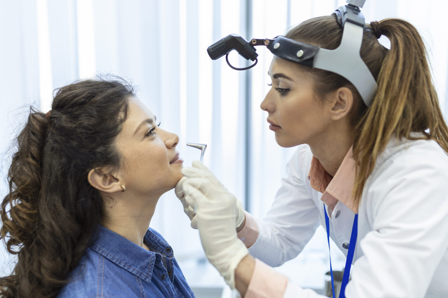 Doctor otorhinolaryngologist checking nose with otoscope of patient at hospital. Nasal congestion, sinusitis, allergy concept. Doctor otorhinolaryngologist checking nose with otoscope of patient at hospital. Nasal congestion, sinusitis, allergy concept.