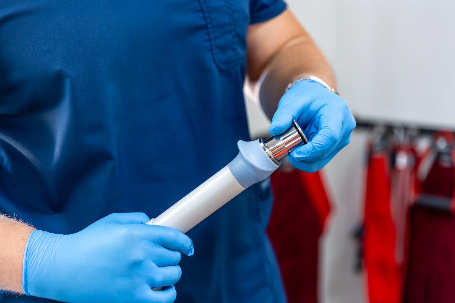 Shock wave therapy device with male doctor hands in rubber gloves. Shock wave therapy device with male doctor hands in rubber gloves.