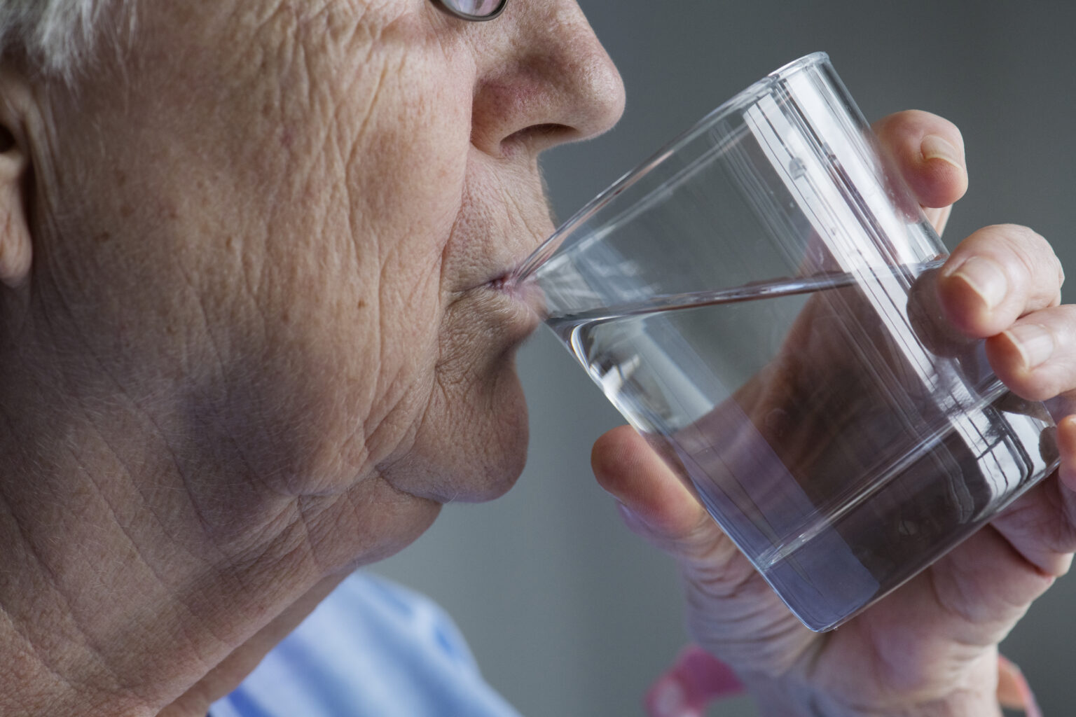 Side view of elderly woman drinking water Side view of elderly woman drinking water