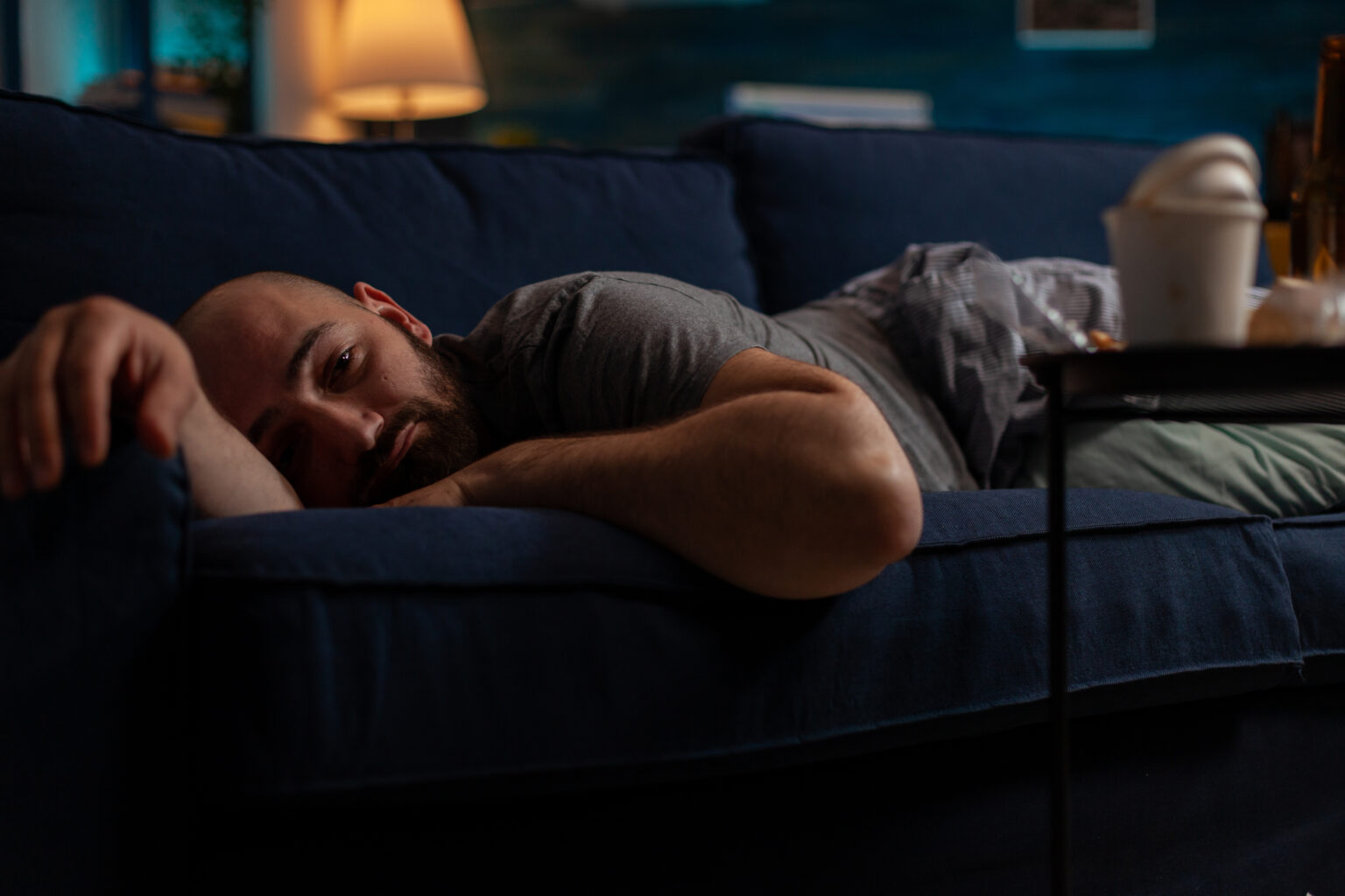 Depressed anxious adult with mental illness laying on couch Depressed anxious adult with mental illness laying on couch