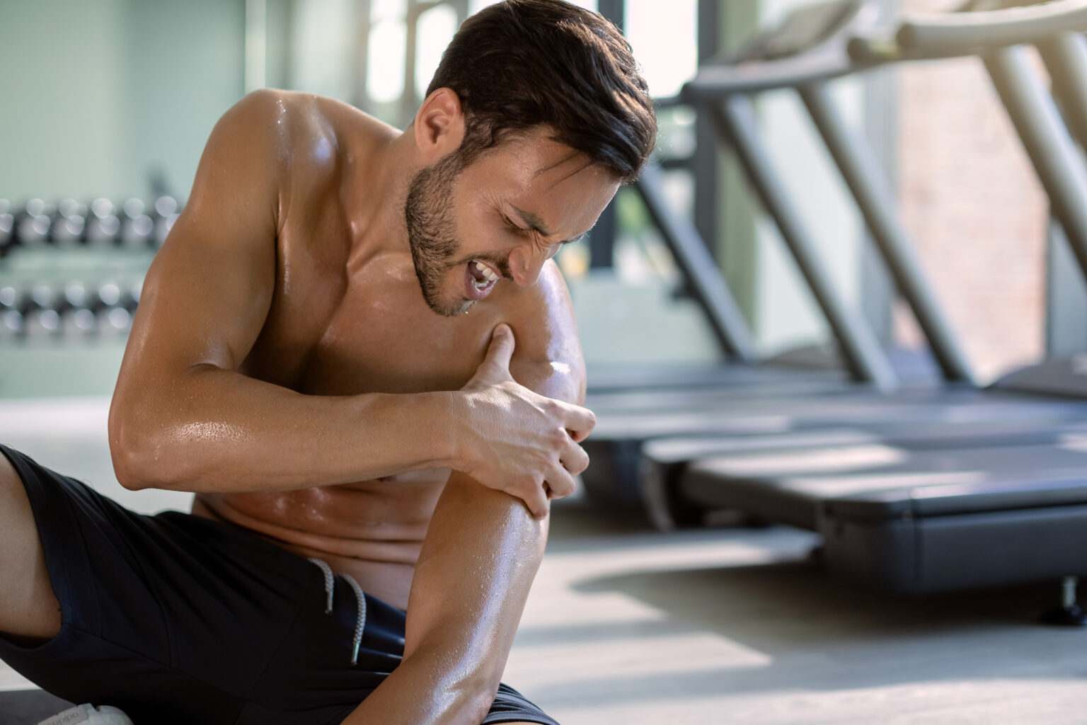 Male athlete injured his shoulder during gym’s workout. Male athlete injured his shoulder during gym’s workout.