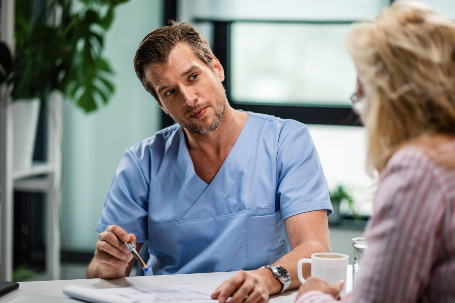 Mid adult doctor talking to female patient at his office. Mid adult doctor talking to female patient at his office.