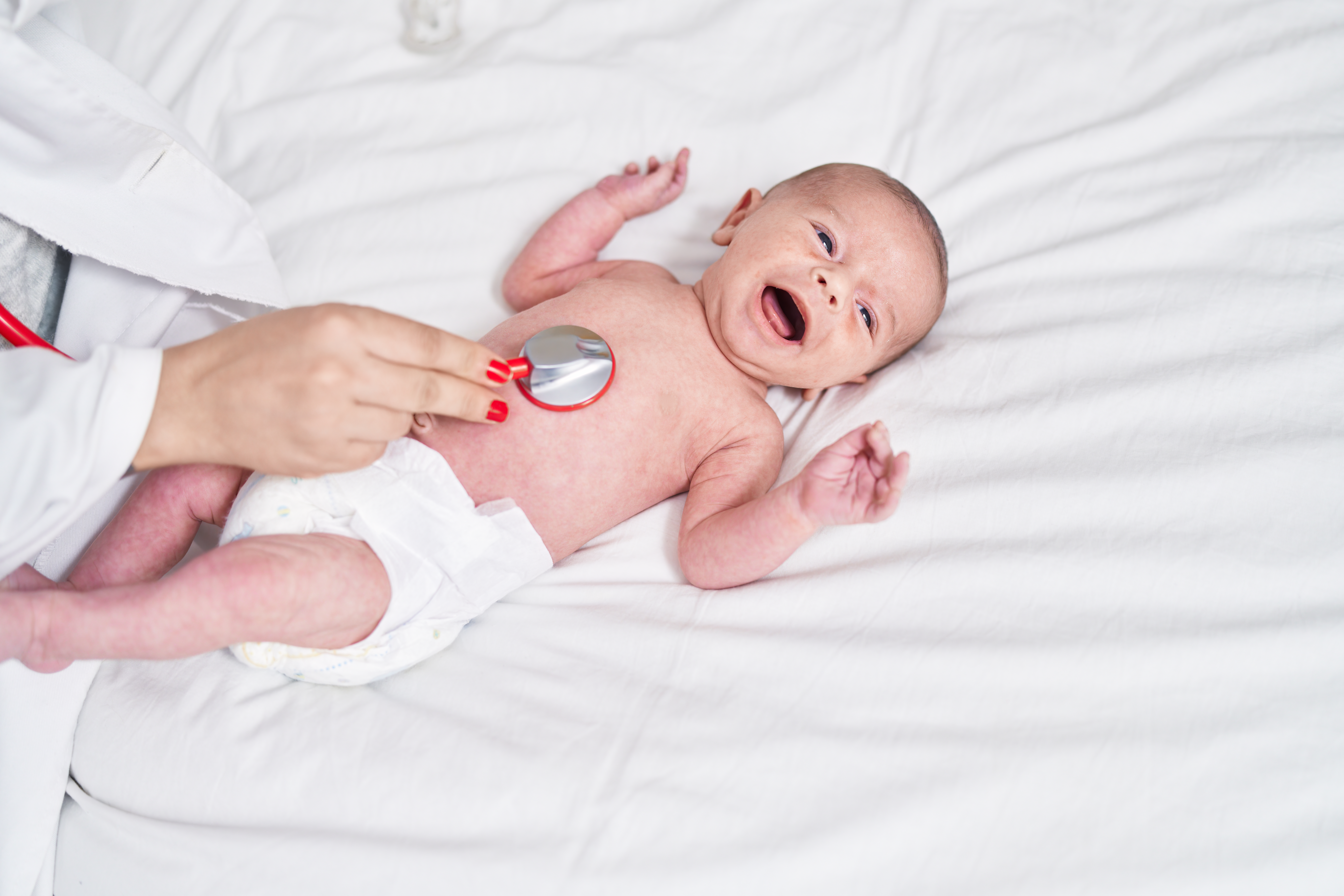 Adorable caucasian baby having heart examination with stethoscope crying at bedroom Adorable caucasian baby having heart examination with stethoscope crying at bedroom