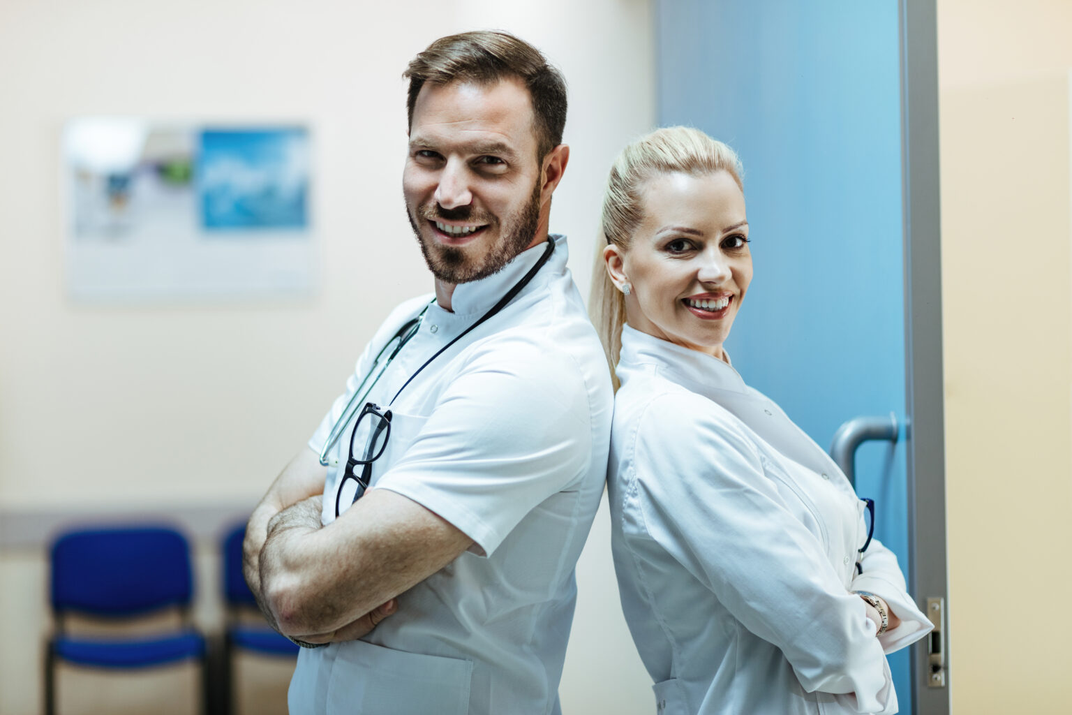 Two happy doctors standing back to back in the hospital. Two happy doctors standing back to back in the hospital.