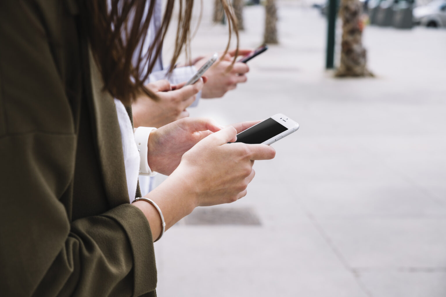 three-people-using-cell-phone-outdoors three-people-using-cell-phone-outdoors