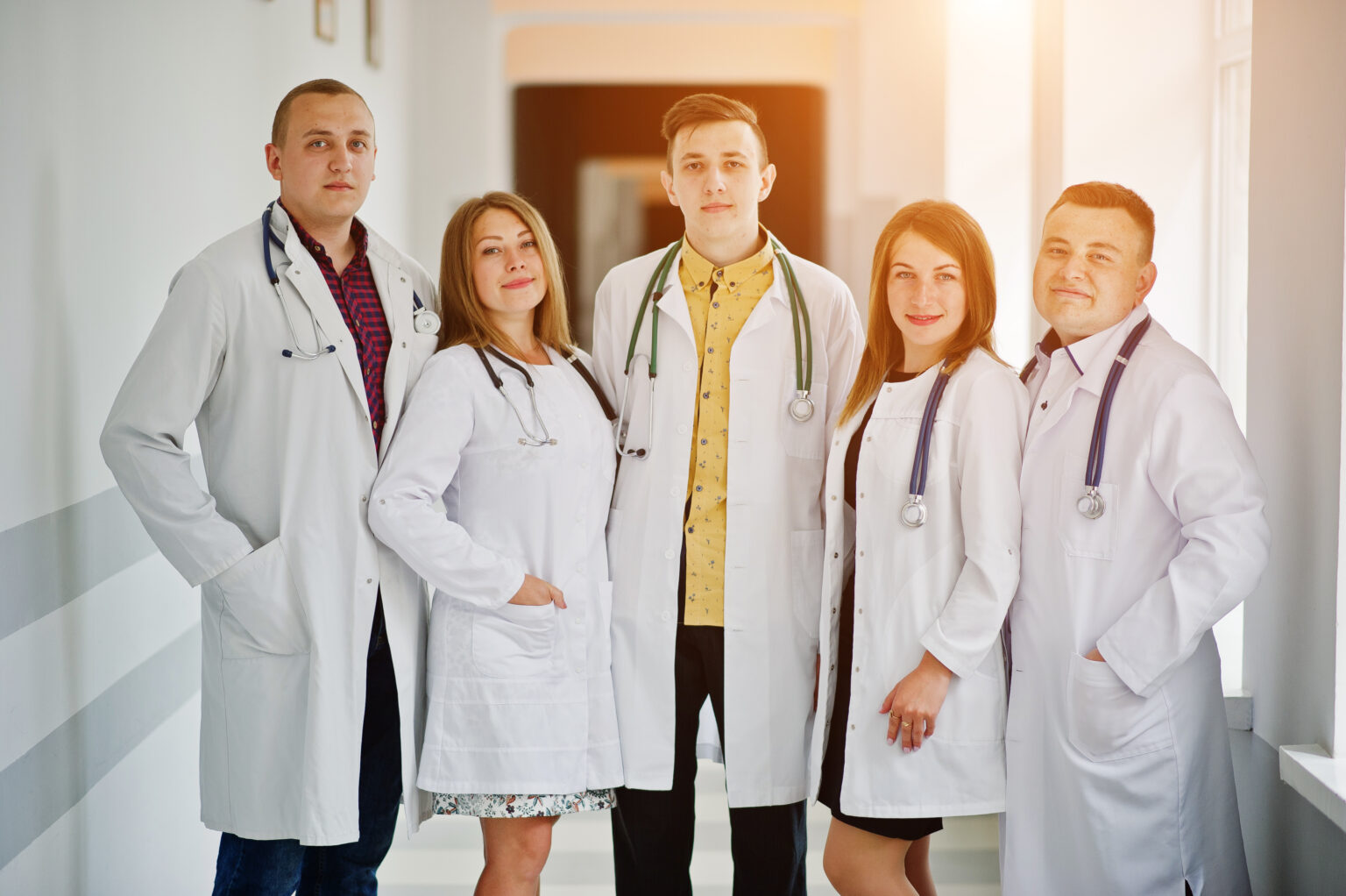 Group of young doctors in white coats posing in the hospital. Group of young doctors in white coats posing in the hospital.