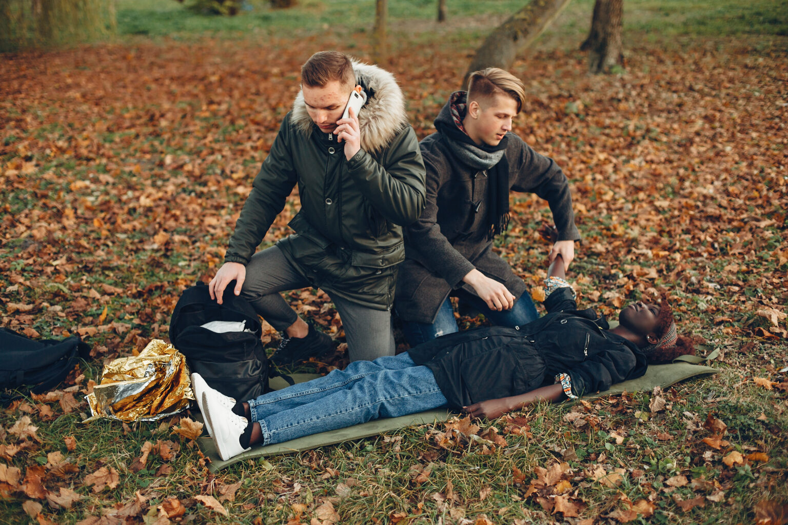 Two boys in a autumn park help a african girl Two boys in a autumn park help a african girl
