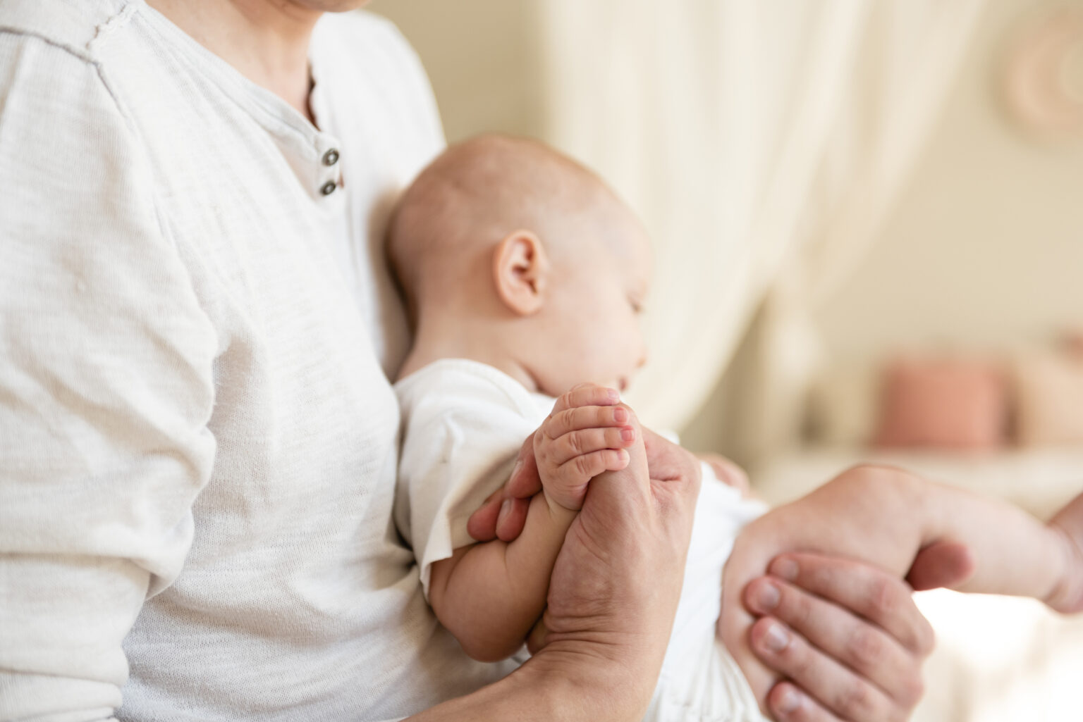 father-holding-hands-with-newborn