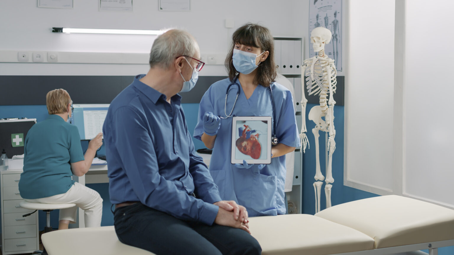 Female assistant holding tablet with cardiovascular system Female assistant holding tablet with cardiovascular system