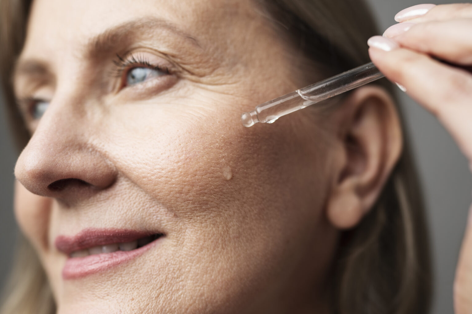 close-up-smiley-senior-woman-using-serum close-up-smiley-senior-woman-using-serum